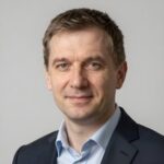 Профессиональный портрет уверенного бизнесмена в студийном освещении на размытом нейтральном фоне