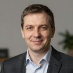 Профессиональный портрет уверенного бизнесмена на нейтральном фоне для сайта авторских туров по Латвии